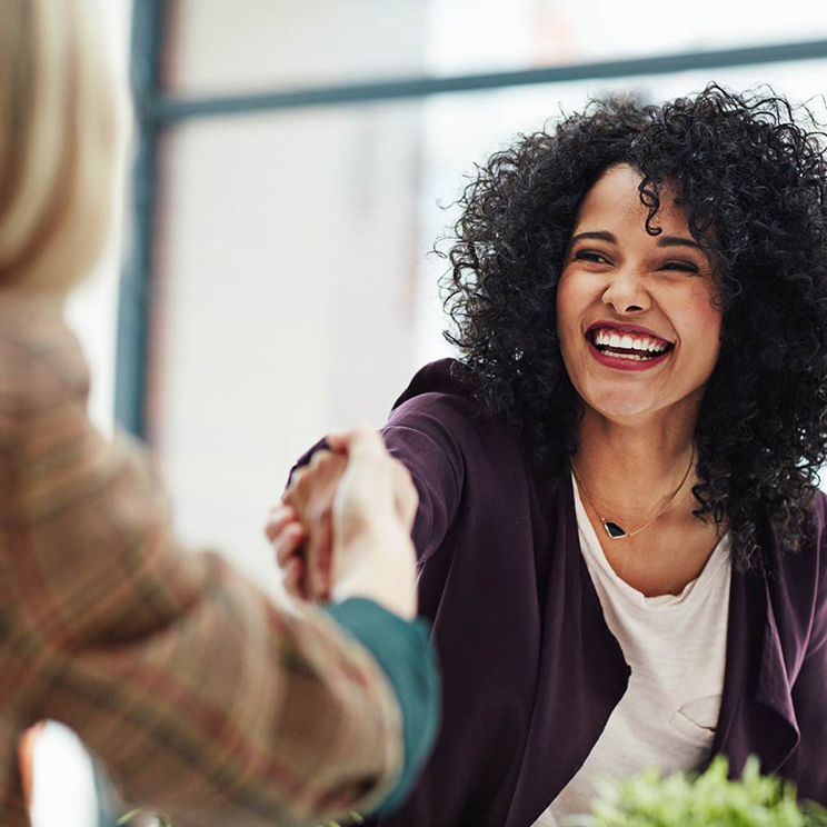 Two business women shaking hands