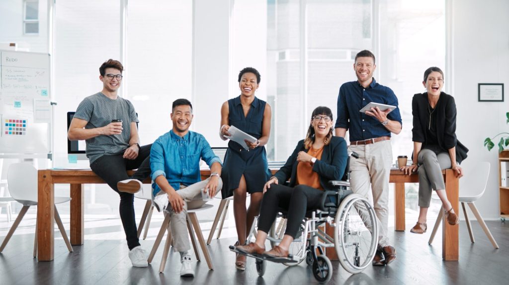 group of diverse people with different ethnicities, genders, and ability. One woman uses a wheelchair.